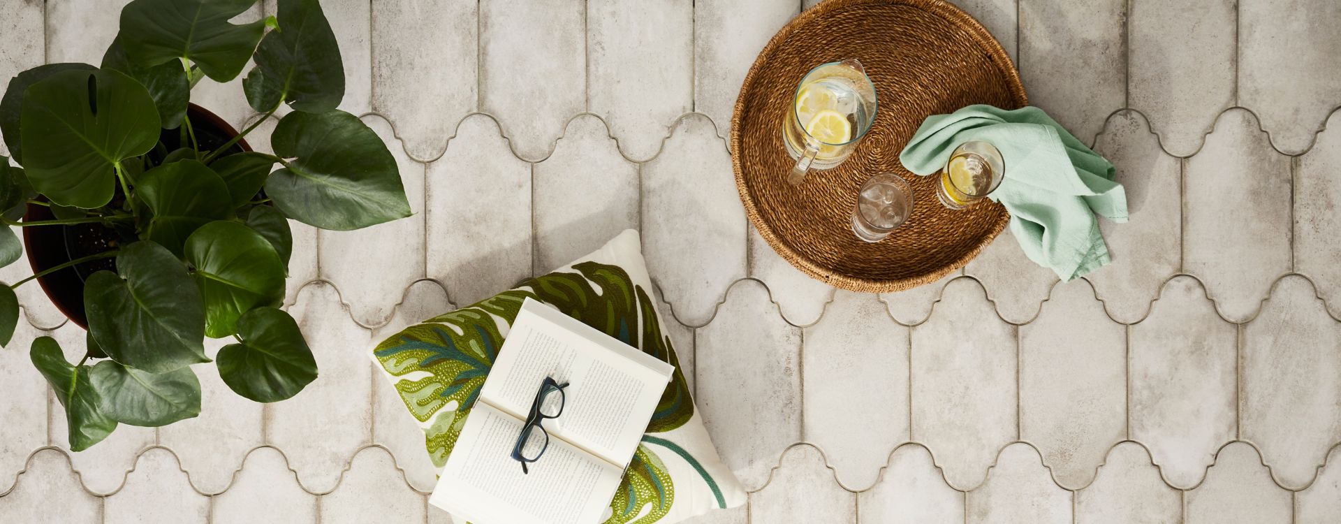 Aerial shot of a grey cement-look porcelain tile patio floor. The tile is a unique oblong shape evoking the air of a Spanish villa.