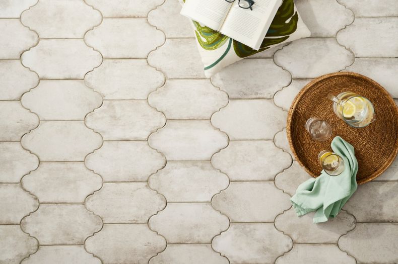 Ivory lantern shaped floor tile in a patio with plants.