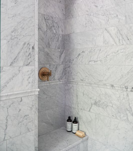 Marble shower with bench and soaps.