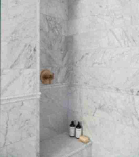 Marble shower with bench and soaps.