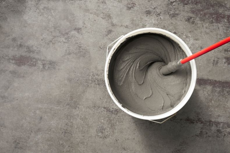 Mixing thinset In a bucket on concrete floor.