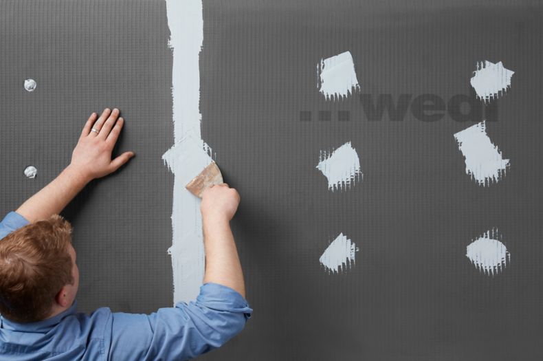 Man in process of installing wedi product.