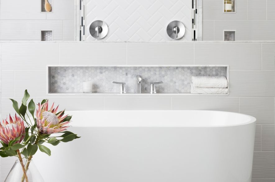 Bathroom with grey and white tile of mixed materials with freestanding tub.