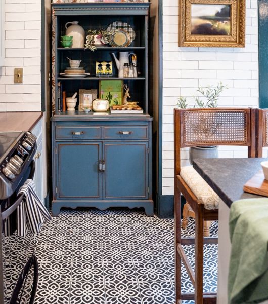 Kitchen with patterned tile floor, white tile wall and blue hutch.