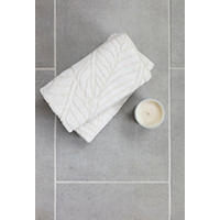 Thumbnail image of Towl and canlde sit on top of 12x24 inch floor tile in gray tone with matte finish.