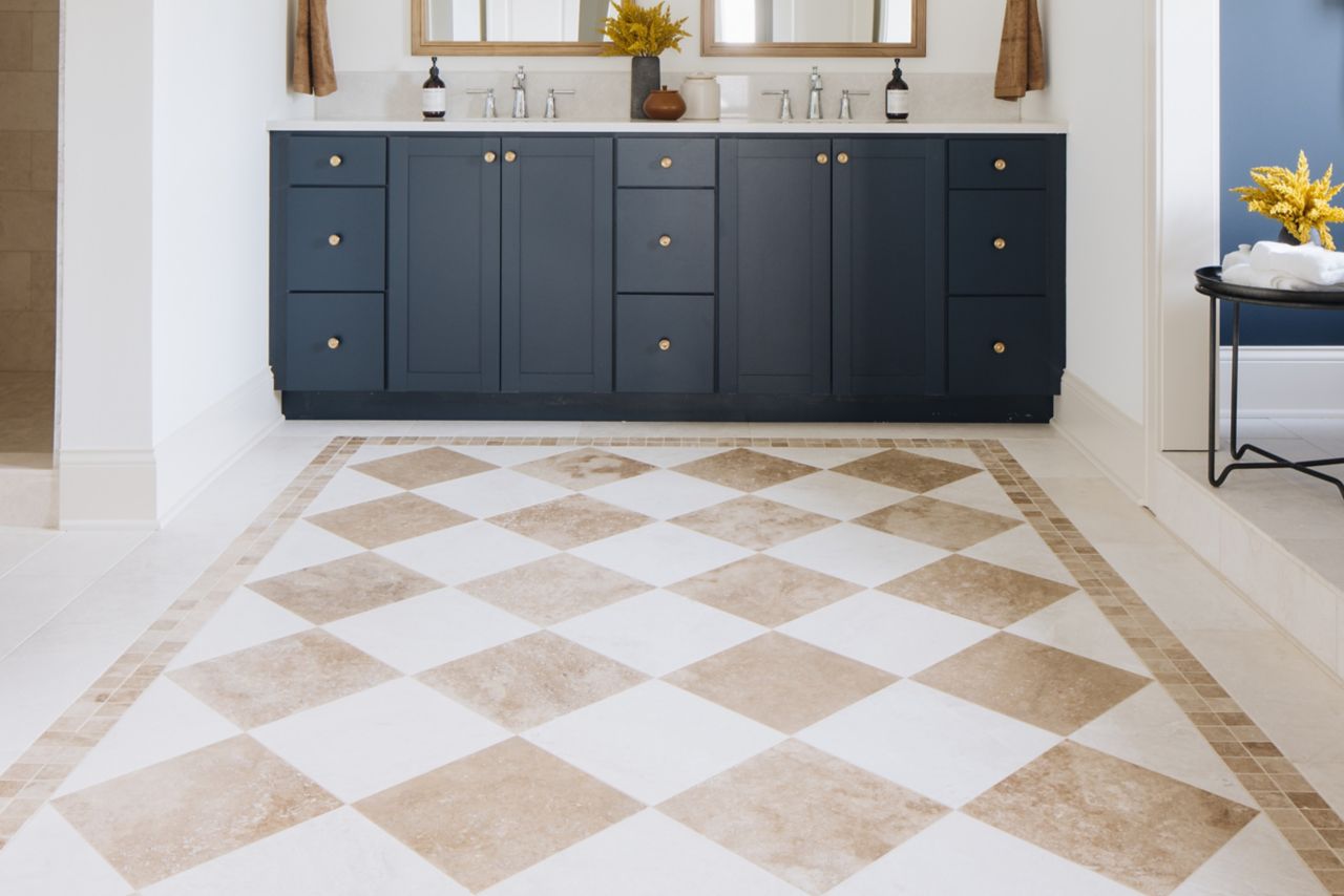 Bathroom with white and cream checkerboard patterned floor and blue sink vanity.