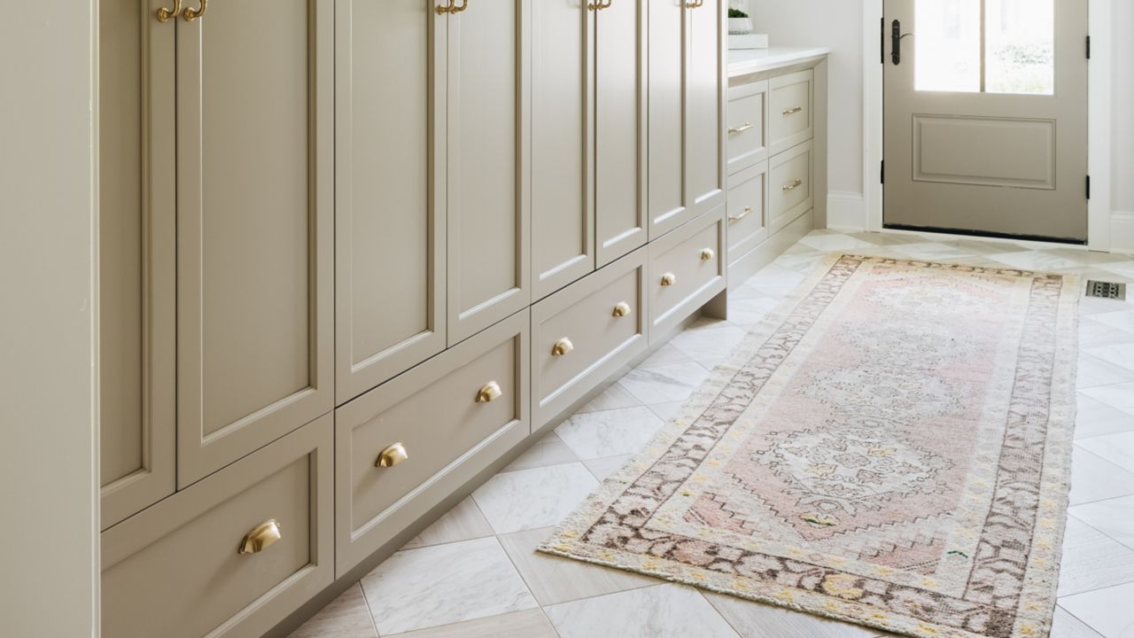 This bright entryway features white and beige stone checkerboard floor tile.