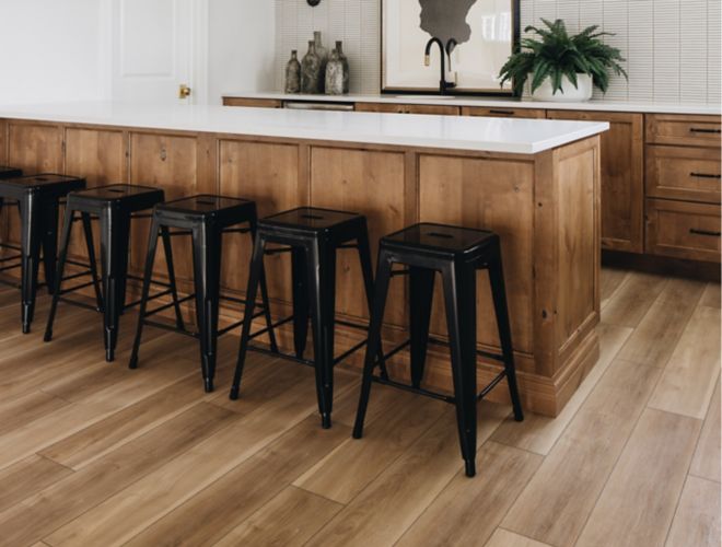 This expansive bar area features wood-look tile floor and small white kit-kat shaped mosaic tile wall.