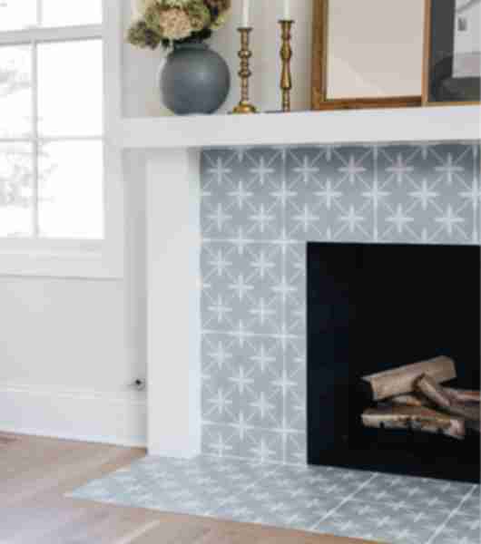 Fireplace featuring blue and white patterned tile on the front face and hearth beneath.