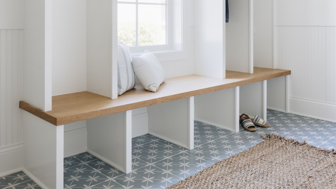 A bright and welcoming mudroom with blue with white blossom pattern floor tile.