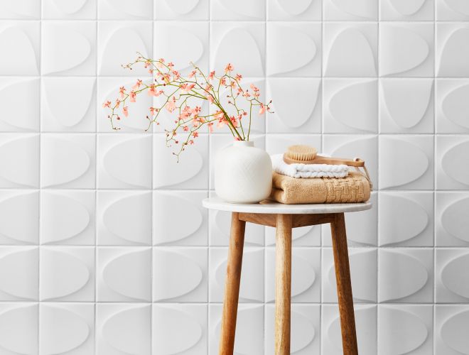 White ceramic 3-D wall tile in spa-like bathroom.