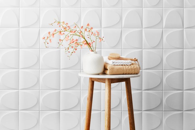 White ceramic 3-D wall tile in spa-like bathroom.