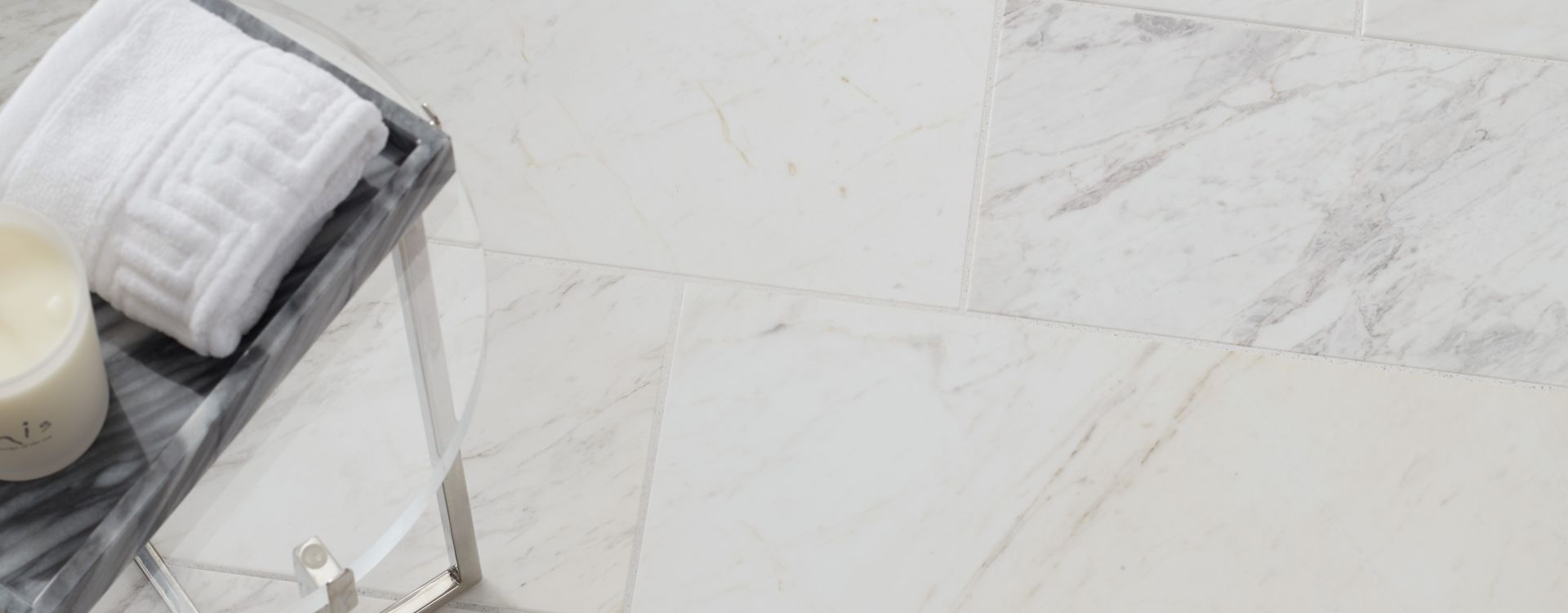 Aerial shot of a white marble subway tile floor with a small table.