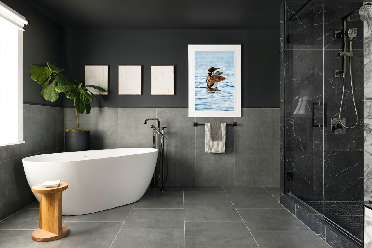 This modern bathroom features large-format grey floor and wall tile and dark grey with white veining shower tile.
