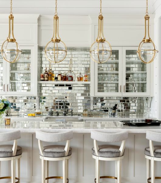 A sit-down bar with a mirrored subway tile backsplash.