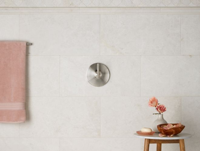 Ivory marble wall tile and arabesque tile in bathroom shower. 