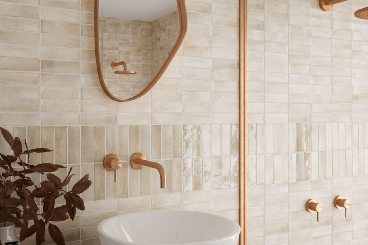 A modern bathroom with cream-colored handmade-look subway tile wall.