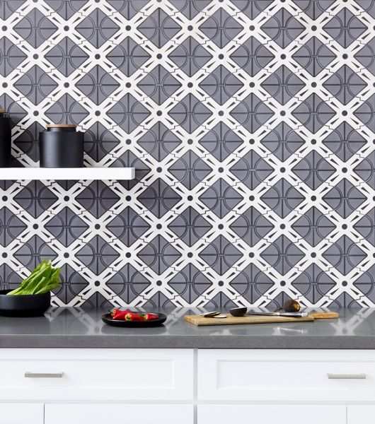 Kitchen backsplash using tile with a bold geometric design in black, grey and white is tempered by the soft, feminine arabesque shape.