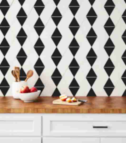 Kitchen with a chic black-and-white accent wall. With the diamonds and triangles on this hexagon tile it creates a woven geometric design. 