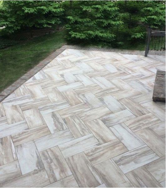 Patio with textured brown and ivory tile in herringbone pattern.