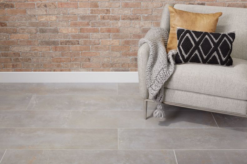 Industrial style lounge area with red brick wall and concrete-look tile floor.