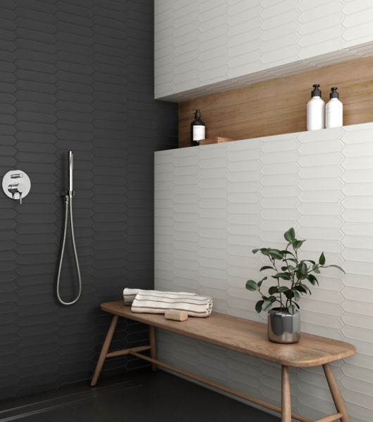 This large, open shower features a black picket tile wall and a white picket tile wall.