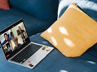 Laptop on couch with REVEL sports fans interacting in a video conference