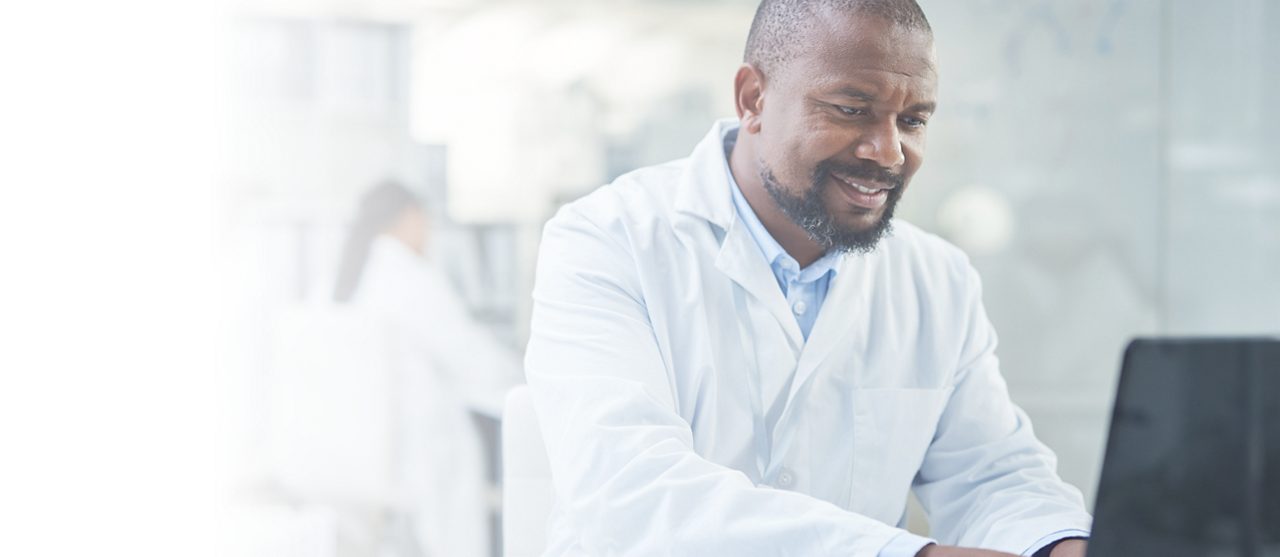  Male doctor typing on a computer
