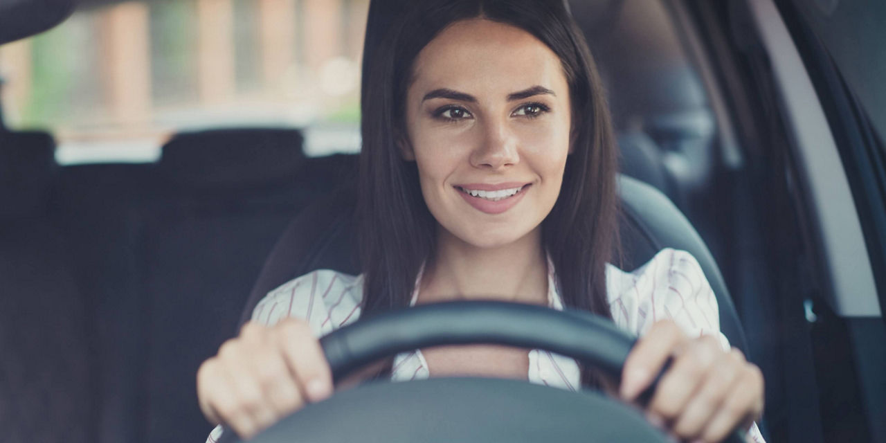 Personne assise au volant d’un véhicule en conduite.