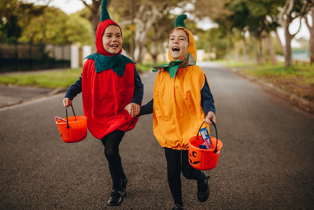 Children dressed in costumes going trick or treating on Halloween
