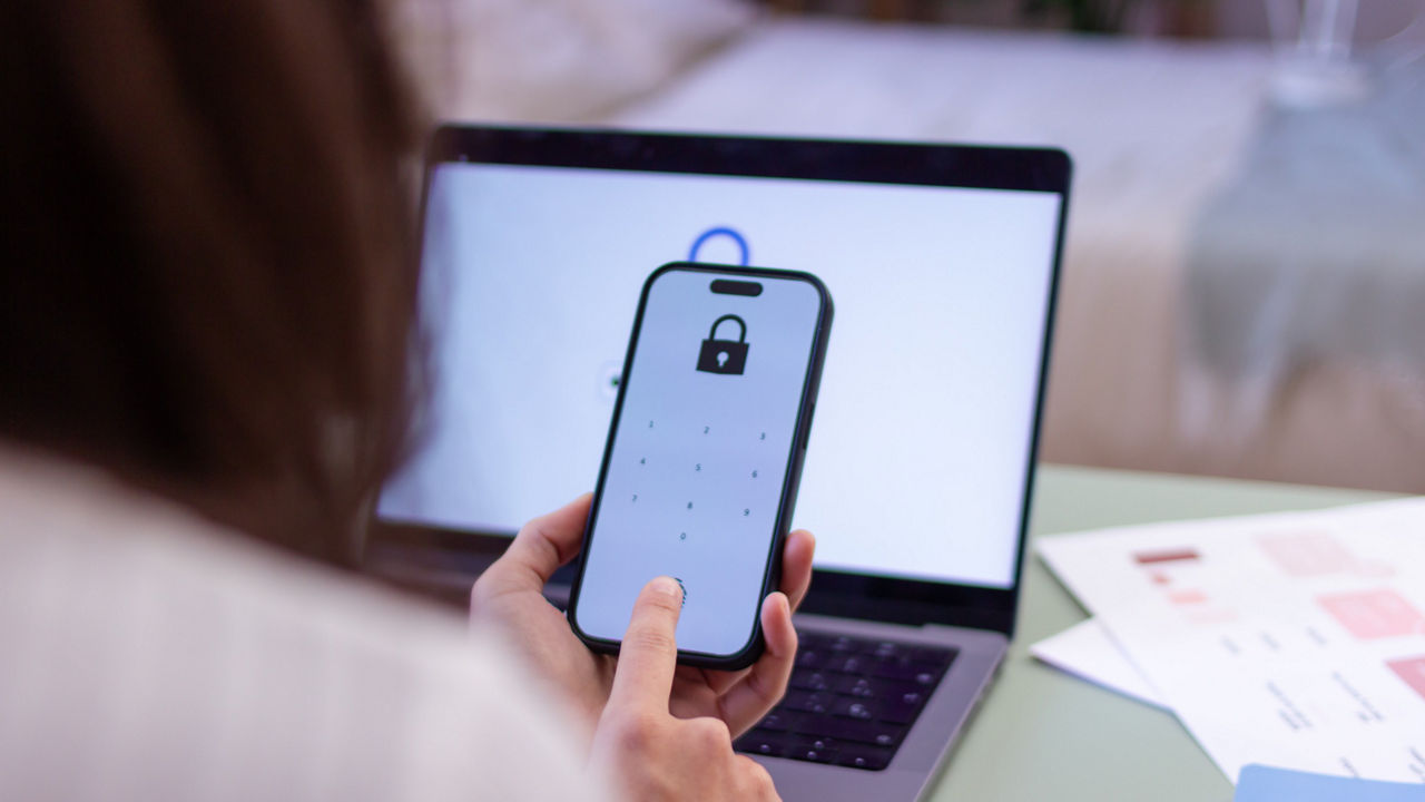Une personne vérifiant l’accès en ligne sur un téléphone intelligent avec un code d’accès.