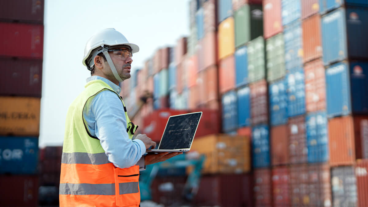 Engineer reviewing operations at a shipping container yard.