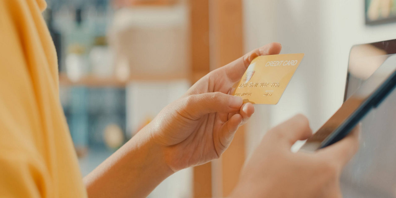 Person using a credit card to make a payment on a mobile device.