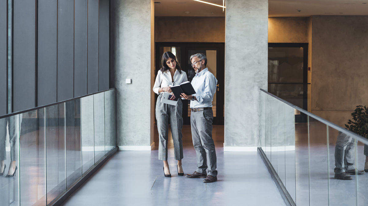 Two people in conversation in office lobby