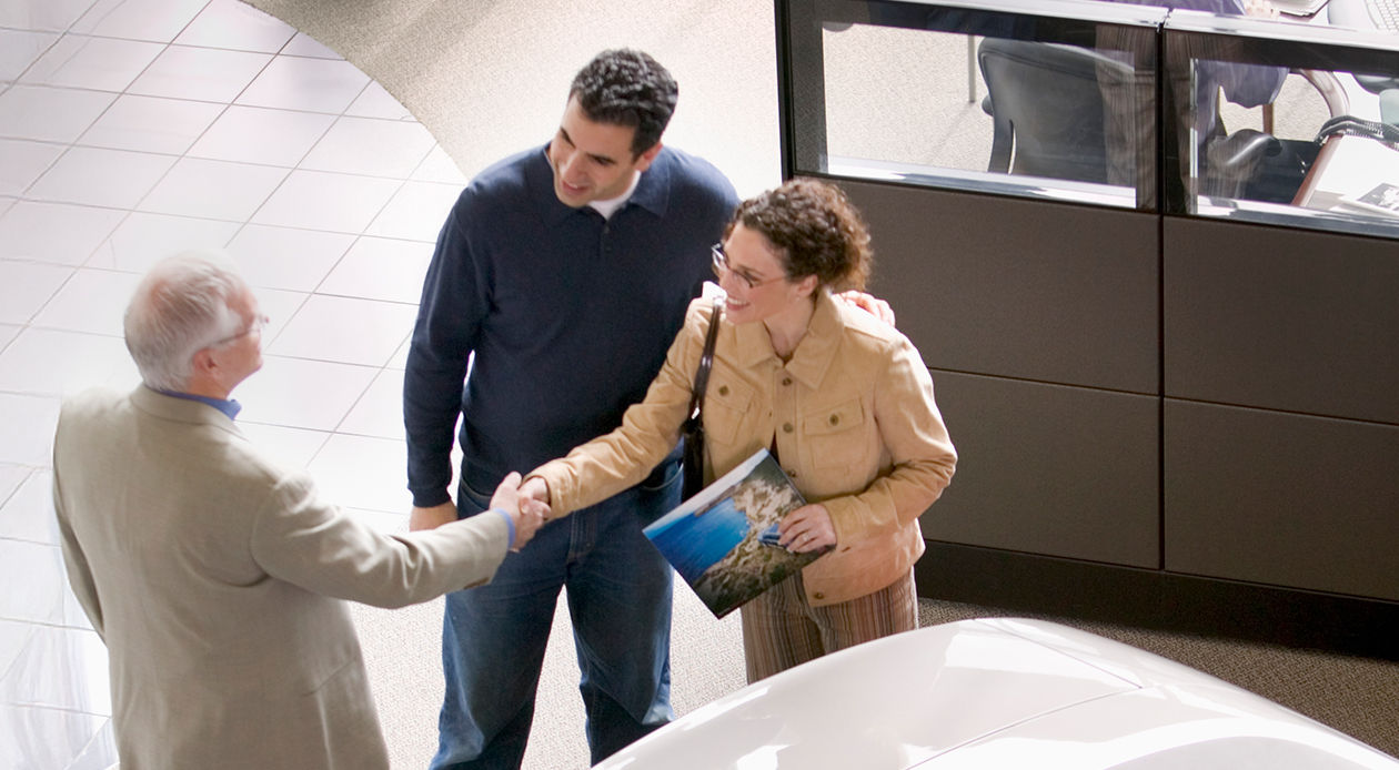 Client et représentant se serrant la main lors d’une consultation de vente ou de service en concession ou au bureau