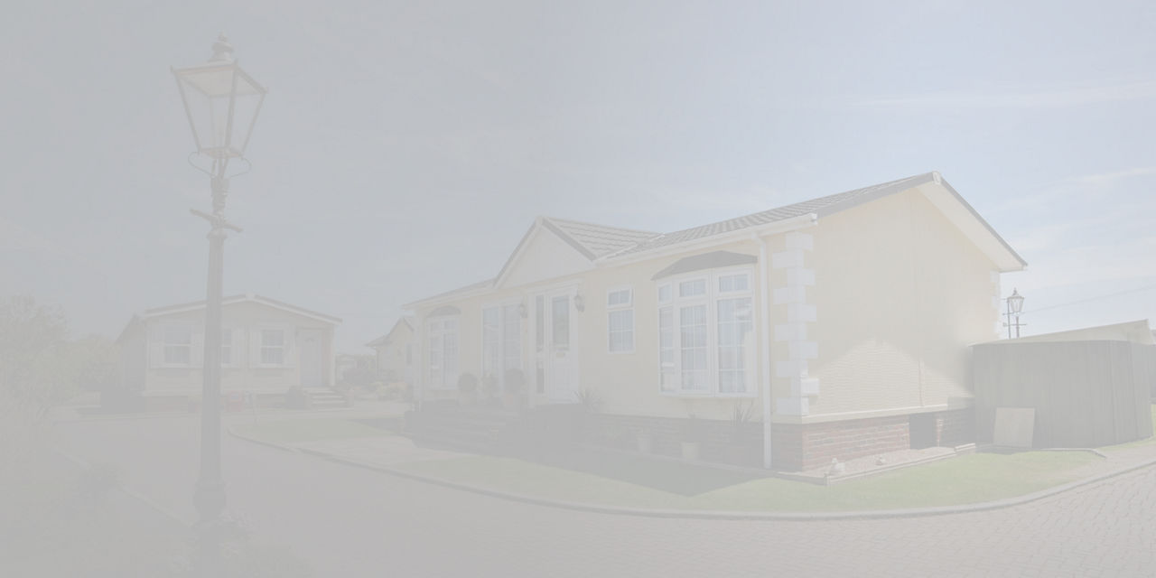 Maison préfabriquée dans une communauté résidentielle avec aménagement paysager et voie pavée.