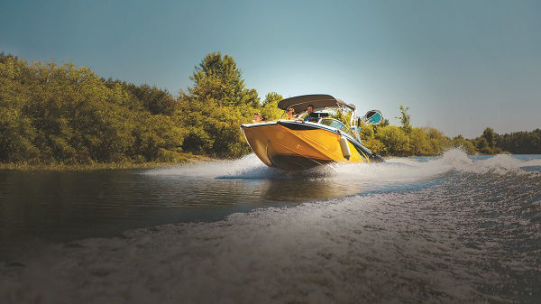 A yellow boat speeding on a lake or river.