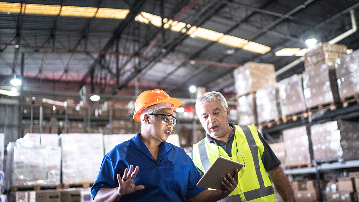 Two warehouse employees in conversation