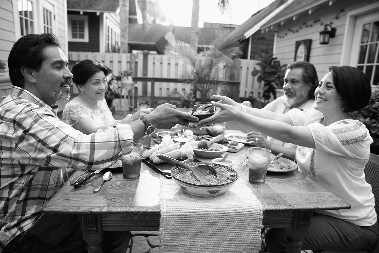 A family sharing a meal around a table outside