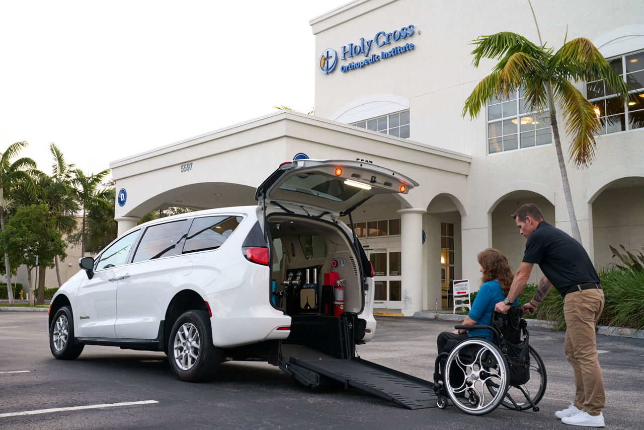 Chrysler Voyager NEMT Rear-Entry lifestyle photo with wheelchair user and attendant