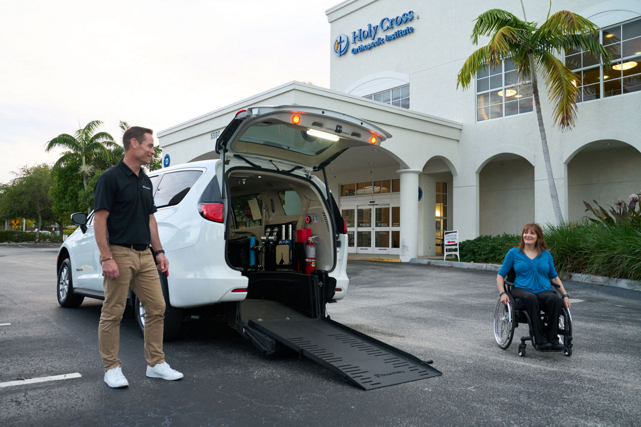 Chrysler Voyager NEMT Rear-Entry liftstyle image with wheelchair user and attendant.