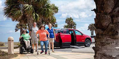 a family with a red chevy traverse wheelchair conversion truck