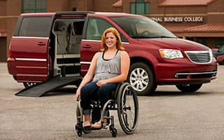 girl in a wheelchair in front of her Chrysler Town and Country handicapvan mobility vehicle