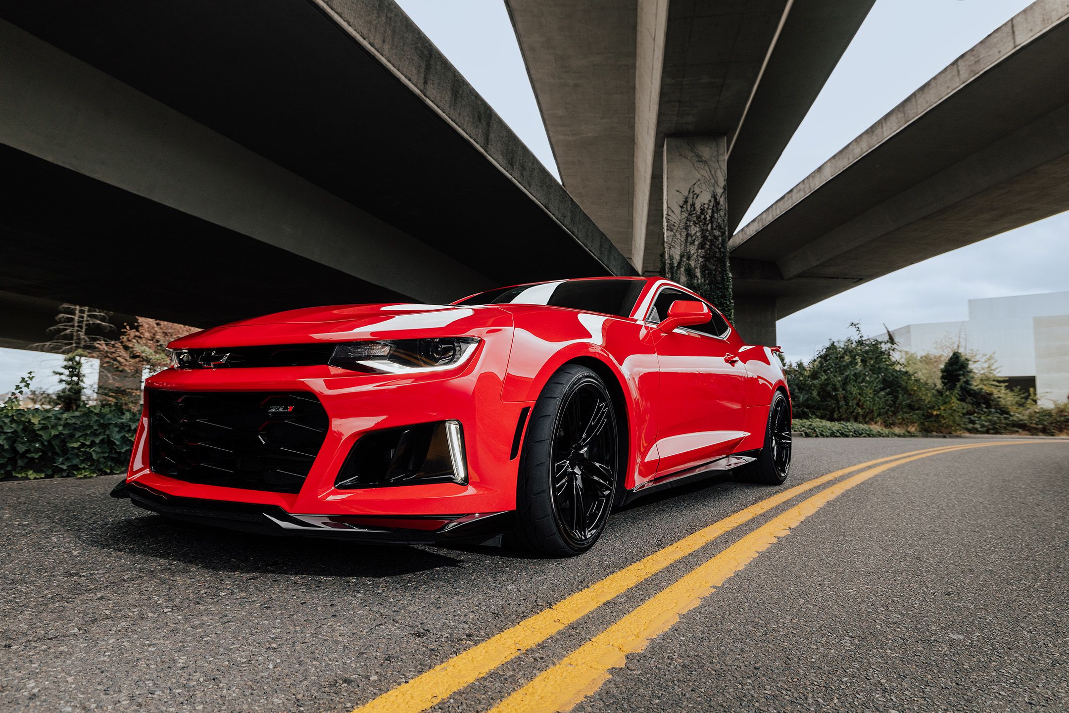 Red Camero under a bridge with INDY 500 V2 Tires