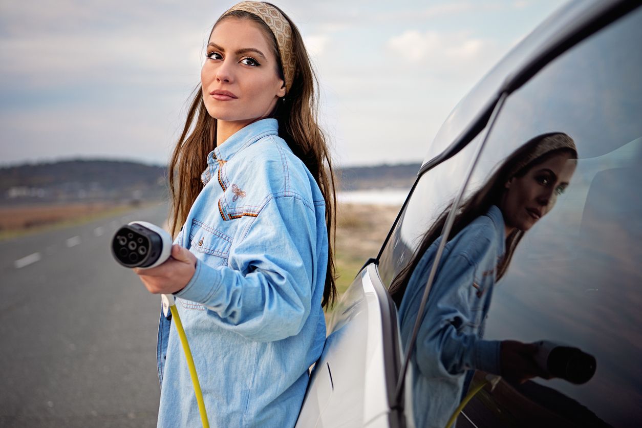 Desperate woman with electric car without power in battery is looking for help