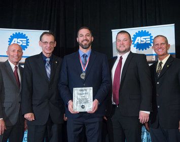 ASE Technician of the Year winner Erik Craddock posing with his award