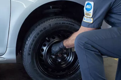 Firestone technician checking the tire pressre  on a tire.