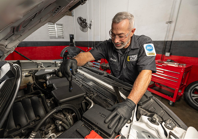 A technician placing a tire on its side in a garage.