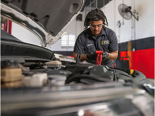 A technician testing a car battery.
