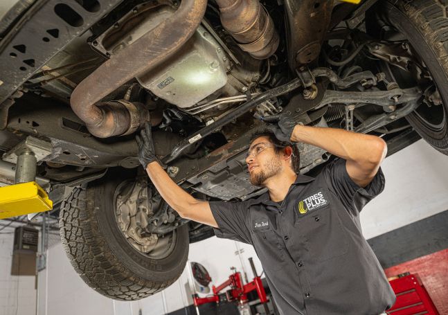 An auto technician working under a car.